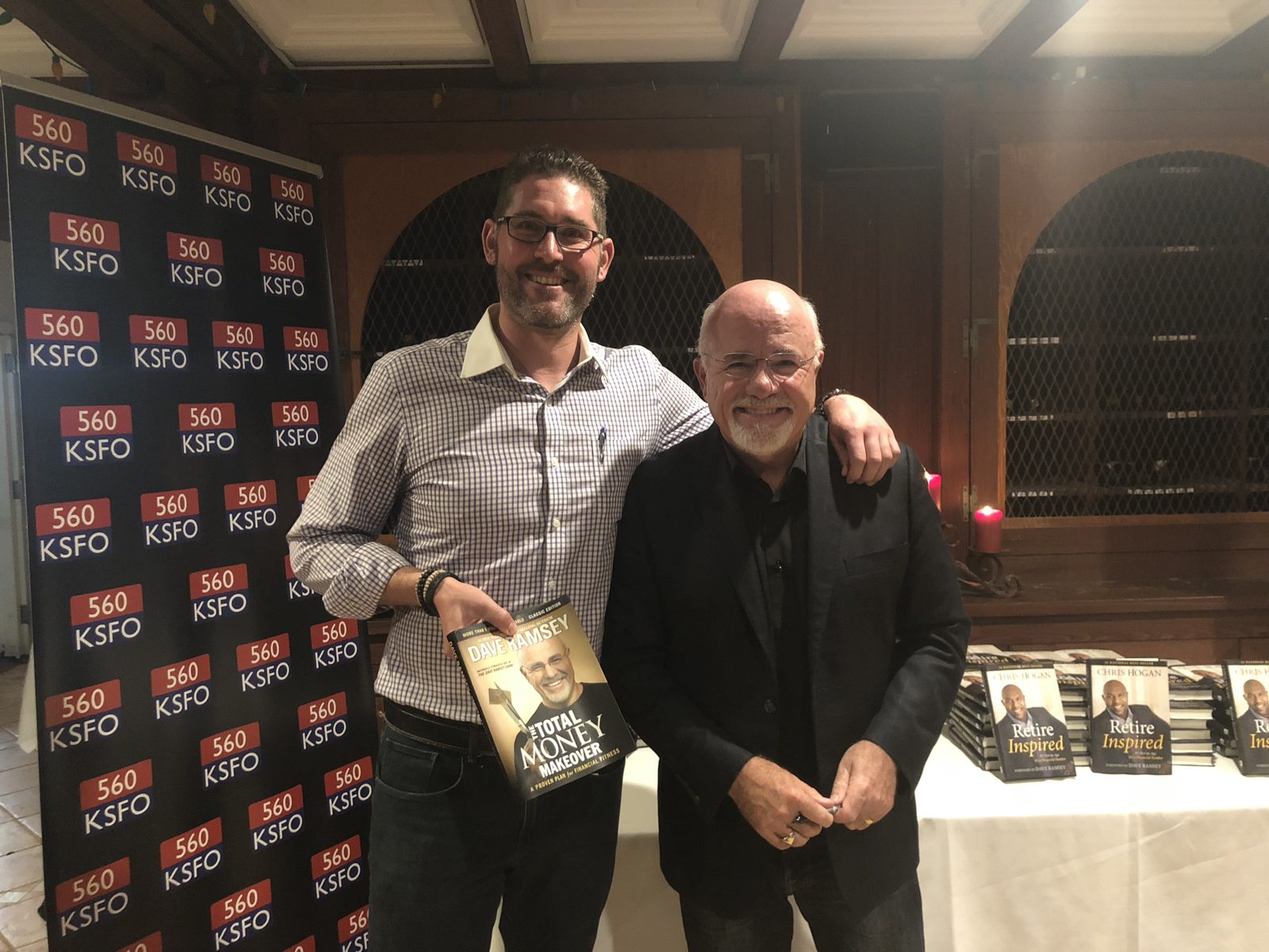 Greg with Dave Ramsey at a 560 KSFO event, holding The Total Money Makeover