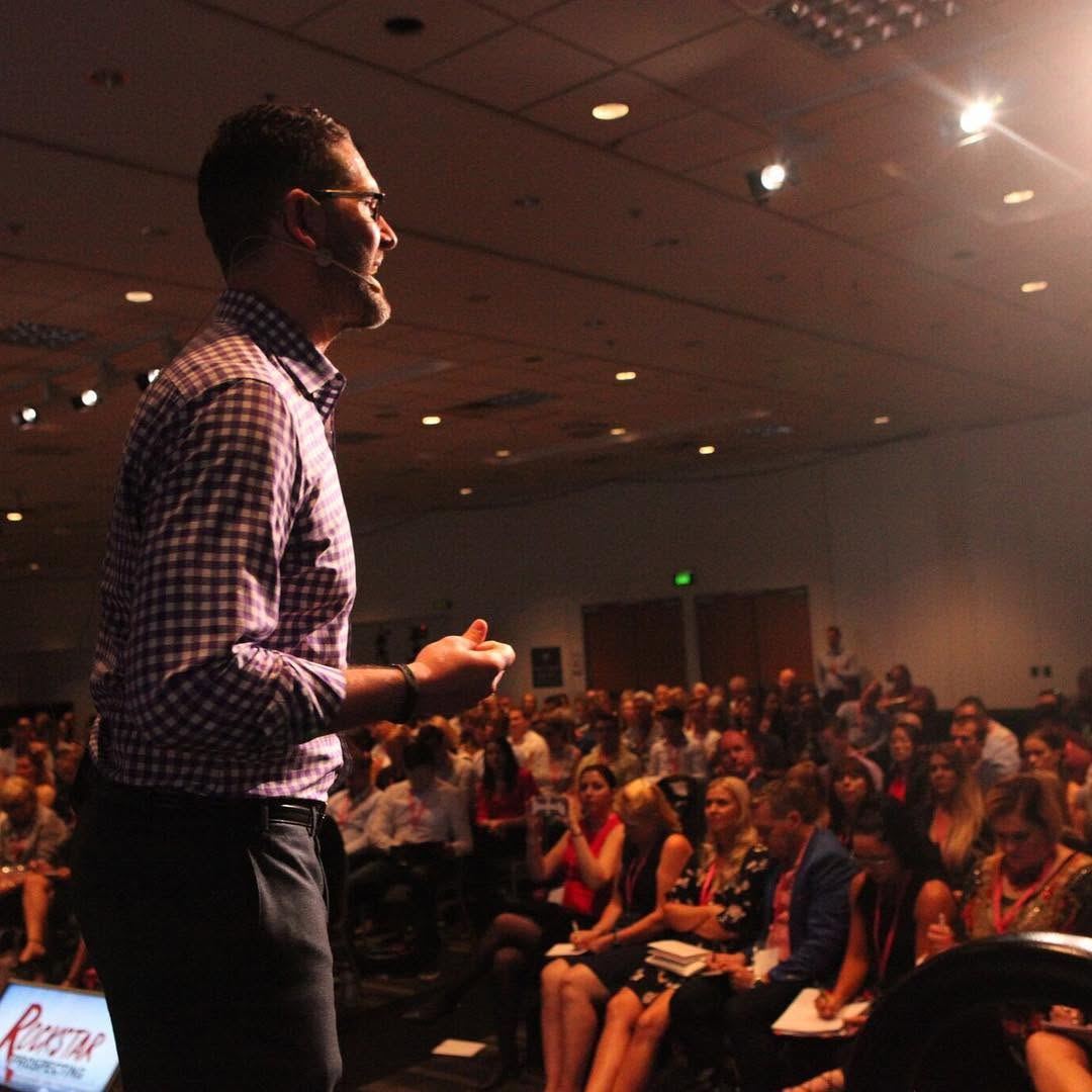 Greg speaking to a packed room